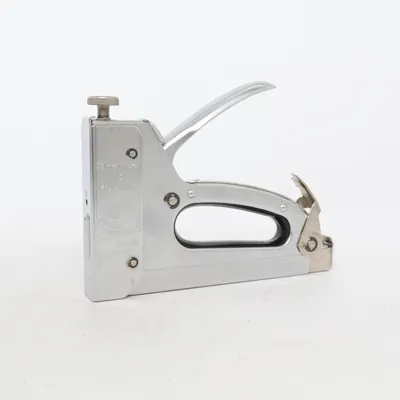 Häftpistol (Sharpo häftpistol, Sharpo 13 Model C, häftpistol, häftapparat, häftverktyg, metall häftpistol, kraftig häftpistol, robust häftpistol, handverktyg, verktyg, DIY, hemmafix, renovering, tapetsering, möbelklädsel, klädselverktyg, byggverktyg, verkstadsverktyg, garageverktyg, verktygslåda, häftning, nitar, klammer, klassiskt verktyg, vintage verktyg, retro verktyg, metallverktyg, praktiskt verktyg, hobbyverktyg, snickeri, inredningsfix) från Sharpo