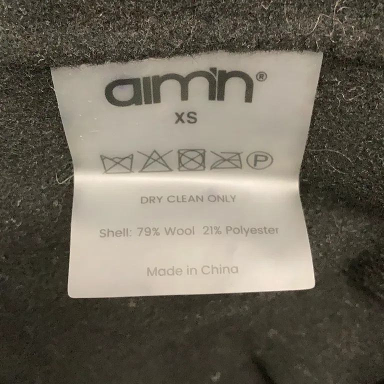 Kappa (Svart) från Aim'n Ull, Polyester - Materialetikett