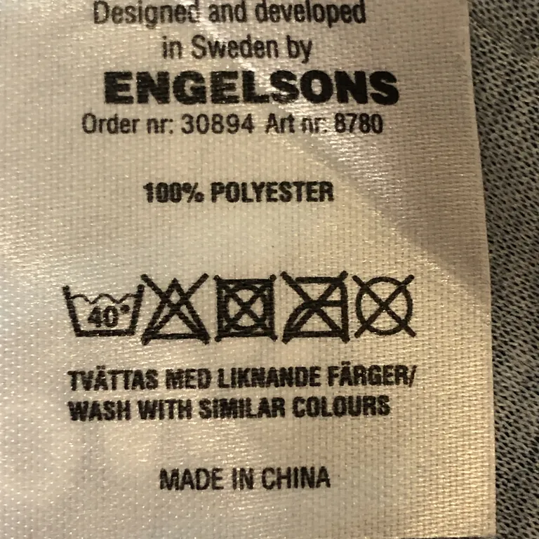 Halsvärmare (Blå, Svart) från Engelsons Polyester - Materialetikett
